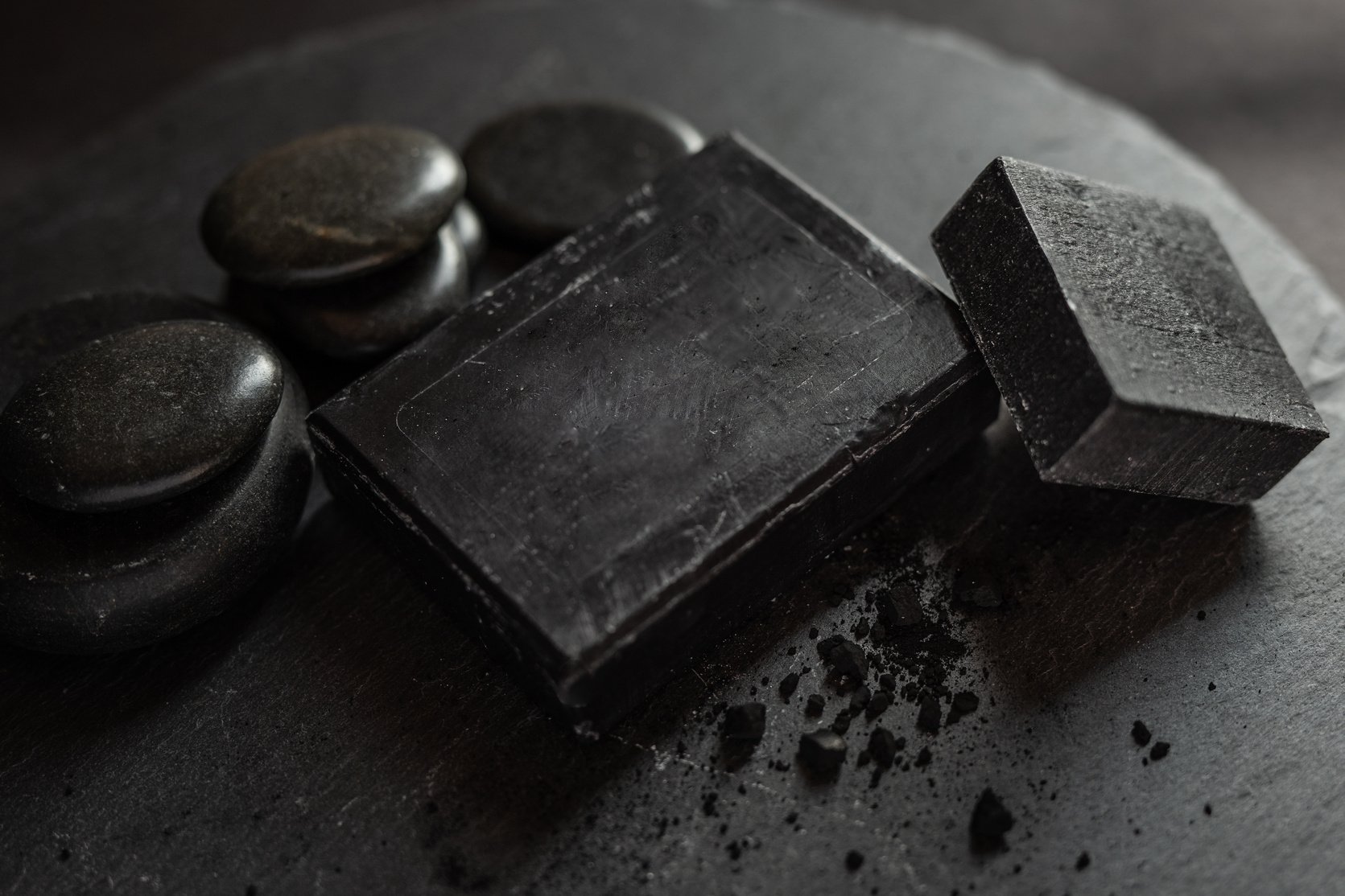 black carbon charcoal soap on a black stone background